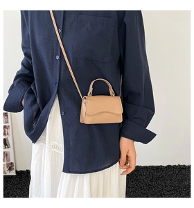 Elegante borsa a tracolla color tè al latte indossata da una modella per riferimento taglia