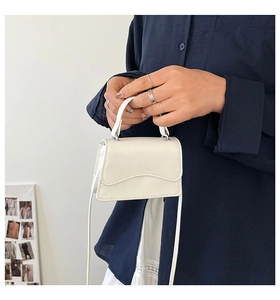 Dettaglio mini borsa bianca in pelle con chiusura magnetica argento e tracolla