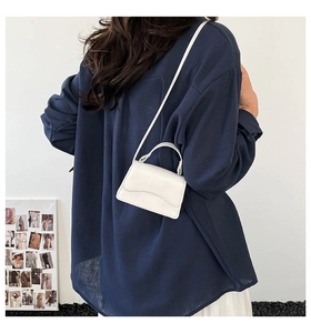 Dettaglio della mini borsa bianca con patta a onde e trama in pelle sintetica liscia