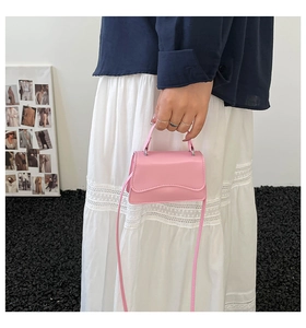 Dettaglio mini borsa a tracolla rosa in pelle con patta ondulata alla moda