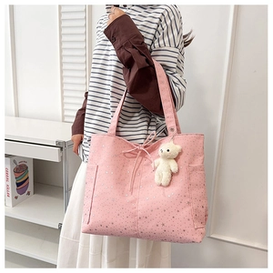 Dettaglio della borsa tote in tela rosa con stelle d'argento, fiocco e orsetto