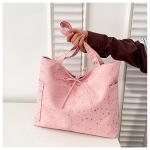 Dettaglio borsa tote in tela rosa con stelle argentate e fiocco decorativo