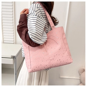 Dettaglio tracolla su una borsa tote in tela rosa con motivi a stelle argentate
