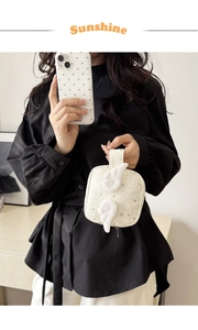 Dettaglio della mini pochette bianca con motivo a stelle grigie e ali d'angelo in peluche