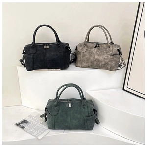 Tre borse Boston vintage in pelle nera, marrone e verde scuro su gradini bianchi