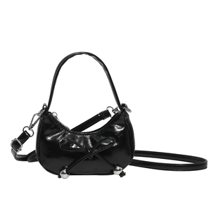 Elegante borsa a mezzaluna nera con fiocco, finitura lucida e borchie argentate moderne