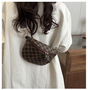 Detail of vintage brown monogram chest bag with golden zippers and ethnic strap