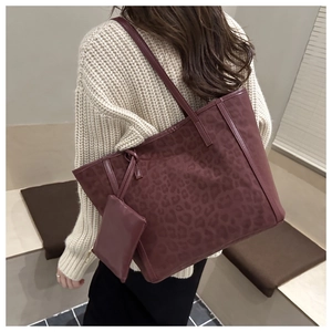 Dettaglio della borsa tote bordeaux con goffratura leopardata e pochette coordinata