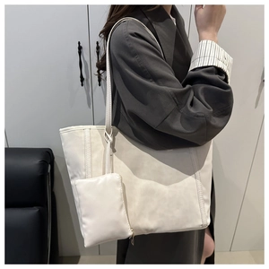 Dettagli della borsa tote bianca minimalista con manici a nodo e pochette abbinata