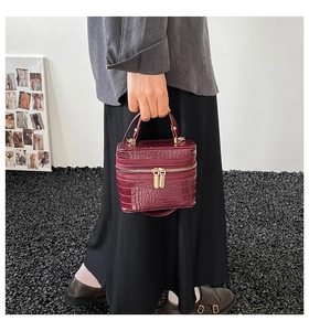 Close-up of deep wine red crocodile textured handbag with premium gold metal hardware