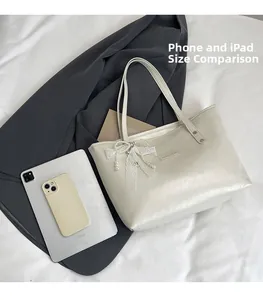 Dettagli in pizzo e perle su borsa color crema con confronto dimensioni tablet