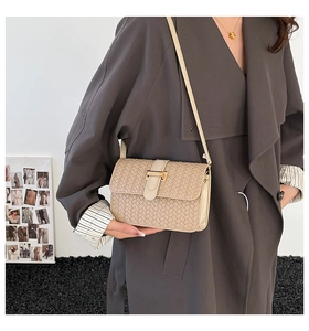 Dettaglio della borsa a tracolla intrecciata beige con fibbia in metallo dorato e pelle PU