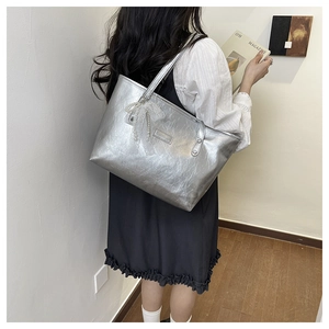 Dettaglio borsa tote argento con finitura metallizzata stropicciata e fiocco in pizzo