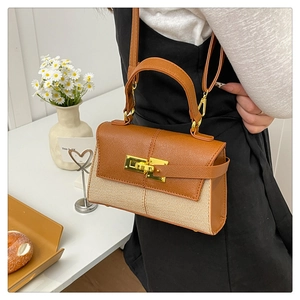 Dettaglio delle cuciture a contrasto e trama intrecciata di una borsa stile Kelly