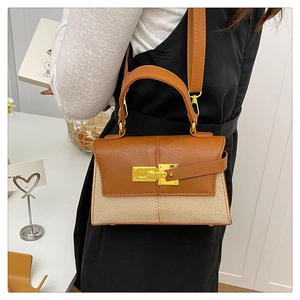 Dettaglio di una borsa chic stile Kelly in pelle marrone e tessuto intrecciato