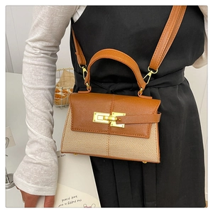 Dettaglio macro della trama intrecciata e patta in pelle marrone di una borsa a trapezio