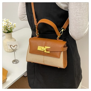 Dettaglio in pelle litchi marrone e tessuto beige intrecciato con chiusura a scatto dorata