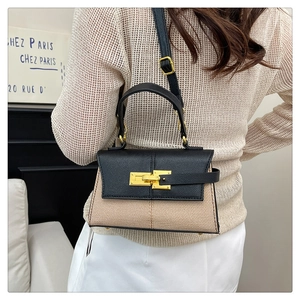 Dettaglio di una mini borsa strutturata con trama intrecciata crema e finiture in pelle