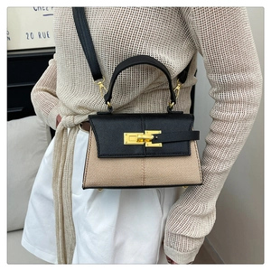 Dettaglio della borsa Kelly bicolore con texture litchi e corpo intrecciato da donna