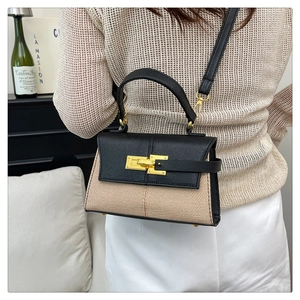 Vista dettagliata di una modella con borsa a trapezio in pelle e tessuto intrecciato