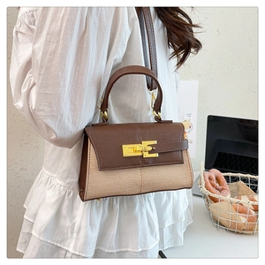 Dettaglio borsa a trapezio bicolore con patta in pelle marrone e corpo in tessuto intrecciato