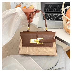 Dettaglio della borsa Kelly bicolore con patta in pelle marrone e tessuto canvas beige