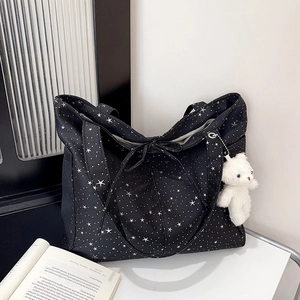 Grande borsa tote in tela nera con stampa di stelle e un ciondolo a forma di orso