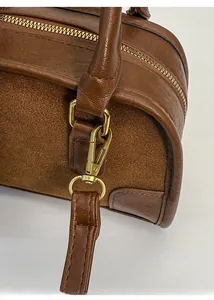 Dettaglio in pelle martellata e camoscio con cerniera in metallo dorato su borsa marrone