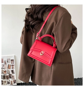 Elegante borsa a tracolla in ecopelle rossa con fibbia ad anello dorata su modella