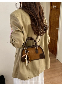 Borsa Boston marrone in pelle e scamosciato con perline in legno su una modella