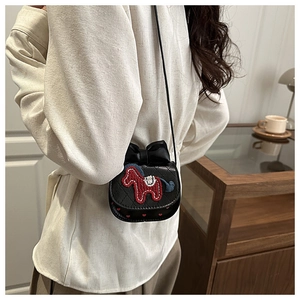 Nahaufnahme der gesteppten schwarzen Mini-Tasche mit Stickerei und großer Schleife