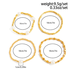 Detail of four-piece gold beaded bracelet set with white pearls and varied bead shapes