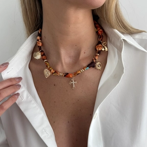 Detail of bohemian leopard print silk cord necklace with gold heart and cross charms