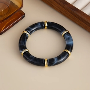 Detail von dunkelgrauen Marmor-Acryl-Armbandsegmenten mit goldenen Metallringen