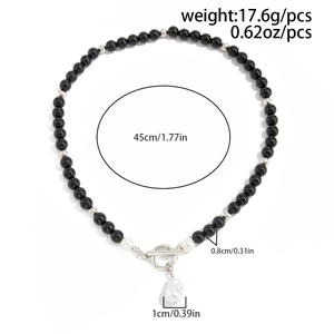 Dettaglio della collana con perle nere, chiusura OT in argento e ciondolo in perla barocca