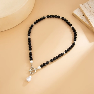 Dettaglio della collana con perle nere, chiusura OT e ciondolo con perla barocca