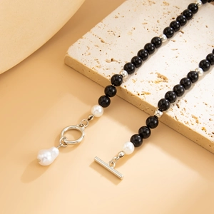 Dettaglio collana di perline nere con chiusura OT argento e ciondolo in perla barocca