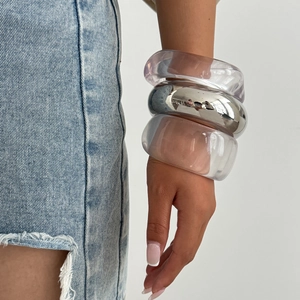 Three-piece chunky bangle set featuring transparent resin and polished silver metal bracelets