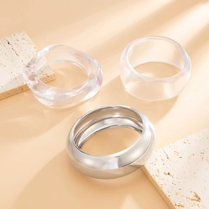 Three-piece acrylic and silver metal bangle set with irregular curved resin designs