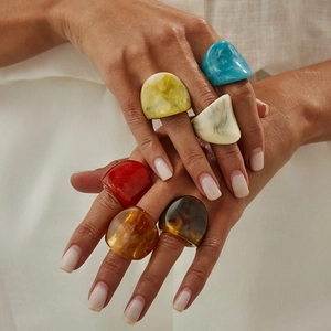 Set of chunky geometric resin rings in colorful marble finishes worn by a model