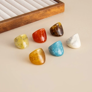 Close-up of six colorful vintage resin rings with marble patterns in diverse vibrant shades