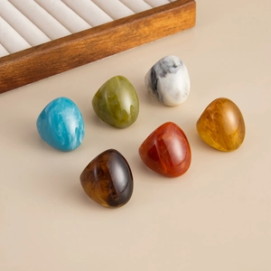 Close-up of 6 colorful irregular resin rings with marble and tortoiseshell textures