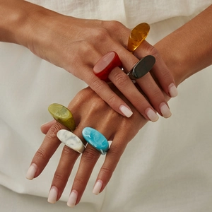 Detailed close-up of colorful irregular resin rings in red, amber, and olive green