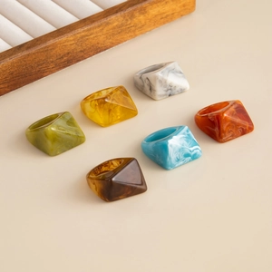 Close-up of geometric faceted resin rings set in six vibrant marble textures and colors