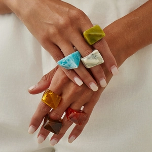 Chic geometric faceted resin rings for women in assorted marbled colors on hand
