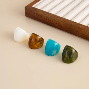 Detail of colorful resin rings in white, amber, blue and green marble patterns
