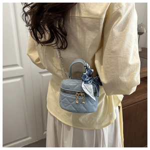 Mini borsa a secchiello trapuntata azzurra con tracolla a catena e foulard sulla spalla
