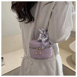 Dettaglio mini borsa trapuntata viola con foulard di seta floreale e tracolla dorata