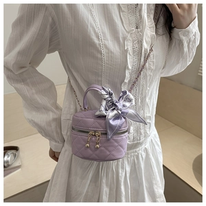 Dettaglio mini borsa trapuntata lavanda con foulard di seta e tracolla a catena dorata