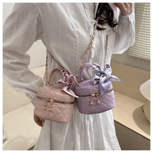 Dettaglio mini borsa trapuntata con manico a foulard floreale e tracolla dorata